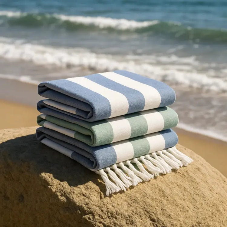 Stack of striped beach towels on a rock with ocean waves in the background
