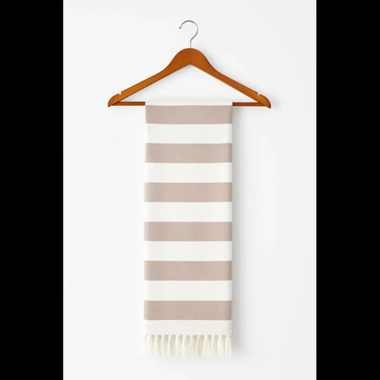 Striped scarf with fringes on a wooden hanger against a white background