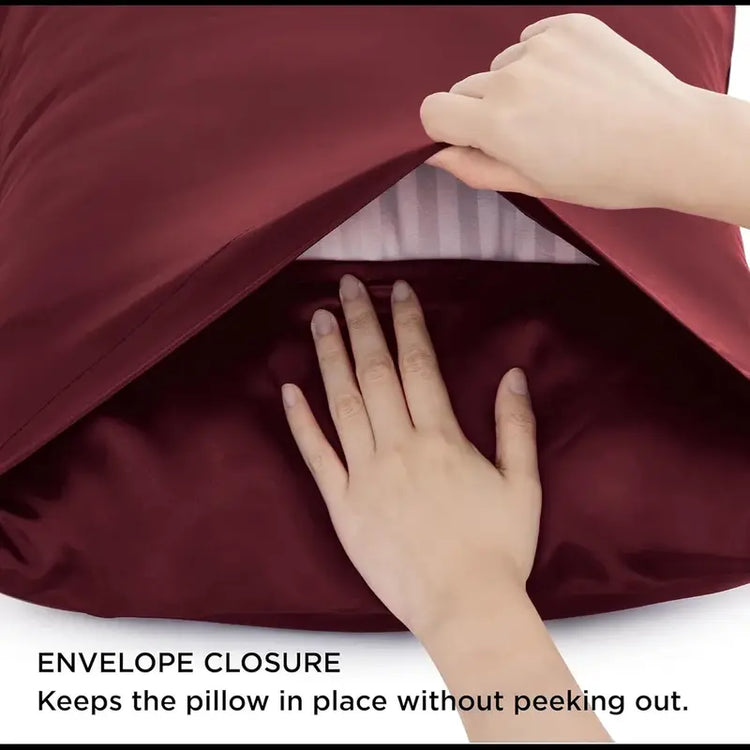 Person closing a burgundy pillow with an envelope closure, text indicating it keeps the pillow in place.