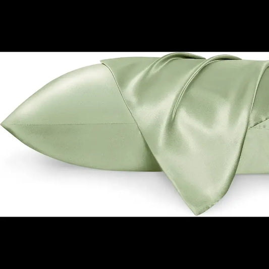 Folded light green satin fabric on a white background