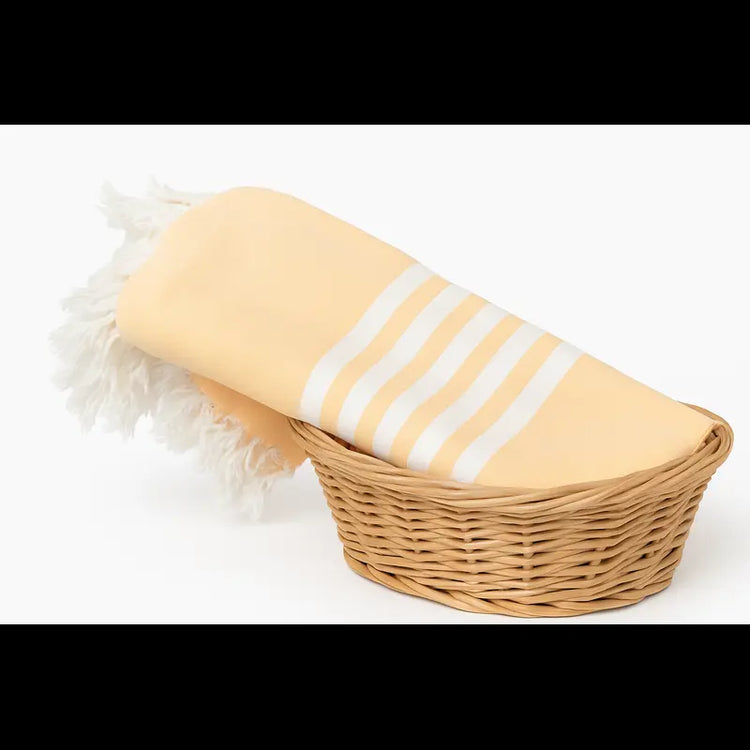 Yellow towel with white stripes on a wicker chair against a white background
