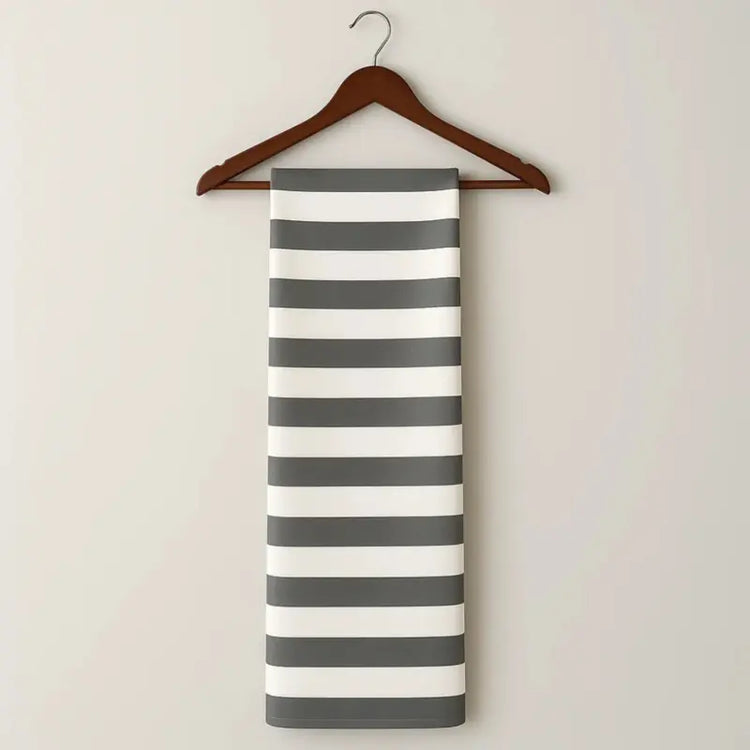 Striped towel on a wooden hanger against a plain background