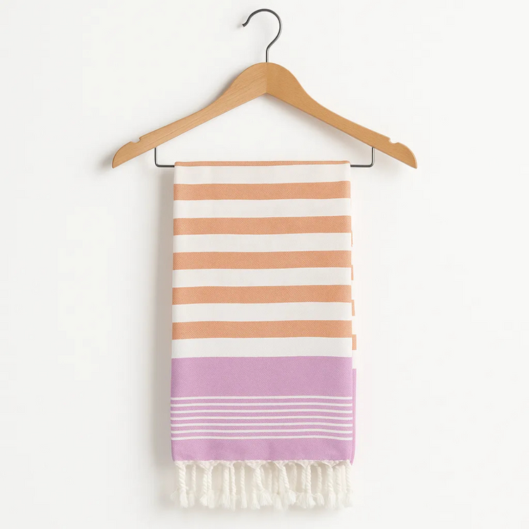 Striped towel with pink and orange stripes on a wooden hanger against a white background