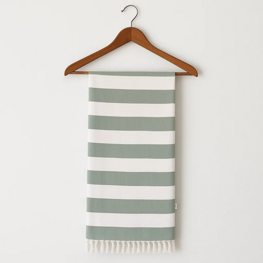 Striped towel with green and white stripes on a wooden hanger against a white background