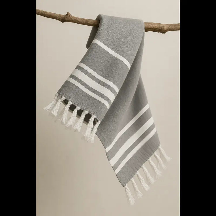 Grey towel hanging on the branch of a tree and flying in the air