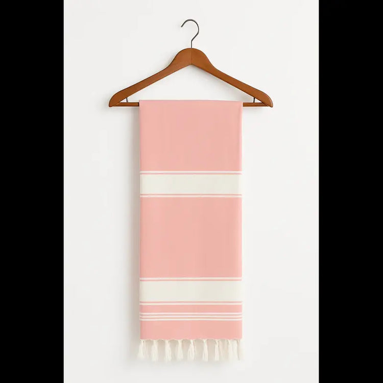 Peach towel with white stripes hanging on a wooden hanger against a white background