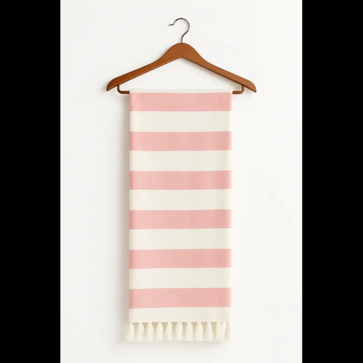 Peach and white striped scarf with fringes on a wooden hanger against a white background