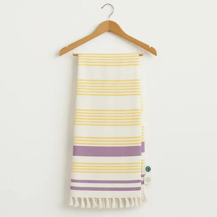 Striped towel with yellow and purple stripes on a wooden hanger against a white background